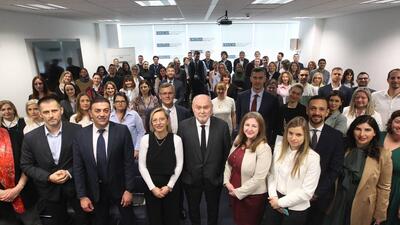 A large group of people in business attire gathered in a conference room.